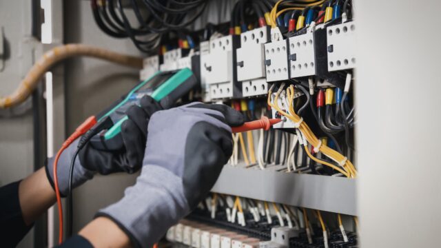 A Master Electrician testing voltage and electrical connections after completing an EV charger installation