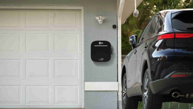 A residential garage featuring a completed EV charger installation with an electric vehicle connected and charging