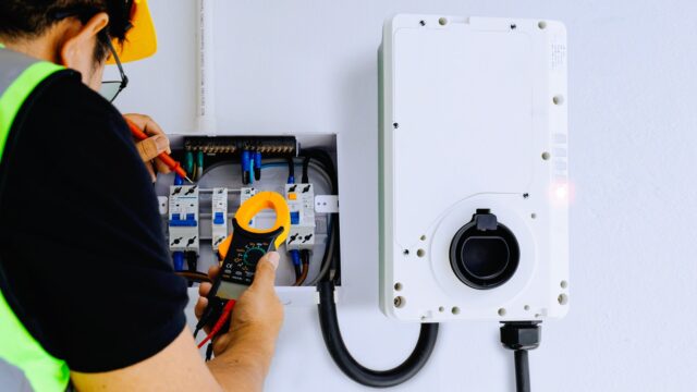 Licensed electrician installing a dedicated 240V EV charging circuit