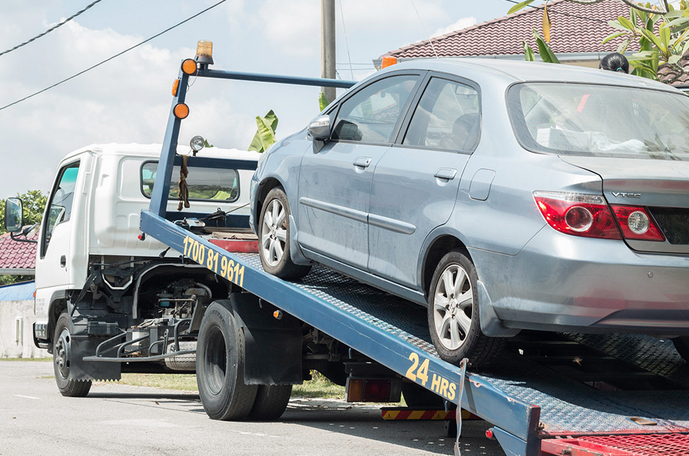 Emergency Accident Vehicle Recovery Detroit by Extreme Towing recovering a damaged vehicle safely with a flatbed tow truck.